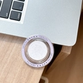 Close-up of circular purple MagSafe phone grip with Gift For You text on a laptop - Purple