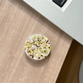 Macro detail of round phone grip holder featuring vibrant yellow and white glitter flakes - Colorful Sequins No.10