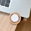Detail eines runden Gift For You Magnet-Handy-Stickers auf einem Schreibtisch aus Holz - Orange