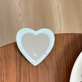 Détail d'un miroir de téléphone en forme de cœur à paillettes bleues sur bois sombre - Vert Menthe