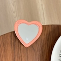 Gros plan du support miroir cœur rose pailleté en résine avec logo sur bois - Orange