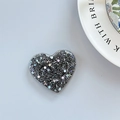 Dettaglio dell'impugnatura per telefono a cuore con paillettes olografiche nere - Supporto a Cuore Adesivo - Nero Cacciatore di Luce