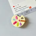 Close-up of a mini palette phone grip with five-color paint dots and tiny brush detail - Transparent Stand Style / Yellow