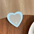 Close-up of heart-shaped blue glitter mirror stand with mine text on wooden table - Blue