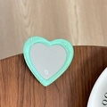 Detail of a mint green heart-shaped phone grip with glitter resin and small mirror - Dark Green
