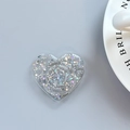 Macro detail of a heart-shaped glitter phone grip with star sequins on a blue background - Adhesive Heart Stand - Starry Pattern