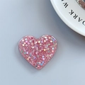 Close-up of heart-shaped glitter phone grip with pink sequins and holographic particles - Adhesive Heart Stand - Light Chasing Pink