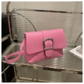 Gros plan d'un sac bandoulière en cuir rose avec boucle argentée sur une étagère - Rose