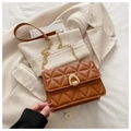 Detail of caramel quilted PU leather texture and gold horseshoe buckle on crossbody bag - Brown