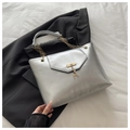 Detailed close-up of silver tote bag with golden chain handle and deer pendant - Silver