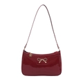 Glossy red patent leather hobo bag featuring a gold bow buckle and shoulder strap - Red