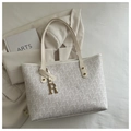 Detailansicht der cremefarbenen Monogramm-Tasche mit goldenem R-Anhänger und Nieten - Weiß