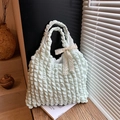 Borsa tote verde menta a pieghe con fiocco in pizzo bianco su un davanzale rustico - Verde