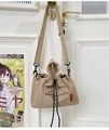Detail of beige nylon tote bag with drawstring closure and orange woven label on front - Khaki