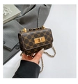 Detailed view of brown checkered mini bag with golden buckle and chain strap on a blazer - Brown