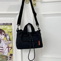 Bolso tote negro utilitario con bolsillo de cordón frontal y correa ancha de hombro - Negro