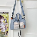 Light blue nylon crossbody bag with contrast pocket and adjustable strap on a white door - Light Blue