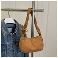 Close-up of brown suede underarm bag featuring a delicate bow strap and zipper - Brown