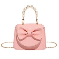 Pink lychee leather crossbody bag with bow detail and white pearl handle - Pink