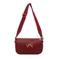 Elegant wine red crossbody bag with golden metal bow detail and adjustable shoulder strap - Red
