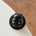 Detail shot of a glossy black bear magnetic phone stand on a white desktop background - Black