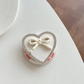 Vista ravvicinata del supporto per telefono a cuore con strass e fiocco in pelle - GD Magnetico - Bianco
