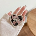 Detailaufnahme der herzförmigen Handyhalterung mit Leopardenmuster und Strassschleife - Transparente Halterung - Strass Herzschleife - Großer Leopardenprint - Rosa