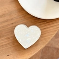 Détail du support de téléphone en forme de cœur avec texture marbre blanc et bord argenté - Support Coeur Galvanisé - Texture Coquillage Colle