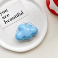 Detail of glossy sky blue cloud phone grip with subtle glitter on a ceramic plate - Magnetic-Blue