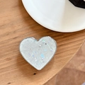 Detailed view of iridescent white heart phone grip with star sequins on wood surface - Electroplated Heart Stand - Starry Shell - Gray