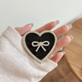 Close-up of heart-shaped phone grip with black sequins, rhinestones, and a silver bow - Transparent Stand - Rhinestone Heart Bow - Sequin - Black