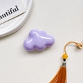Close-up of a glossy purple cloud phone grip with a vibrant orange tassel detail - Airbag Holder - Purple