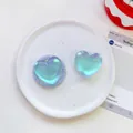 Detail of two laser heart phone grips with iridescent pearlescent finish on ceramic tray - Matte Heart-Iridescent Light Blue