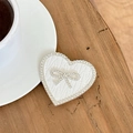 Macro detail of heart phone grip with cable-knit texture and sparkling rhinestone bow - Transparent Stand-Rhinestone Heart Bow-Leaf Texture-White