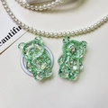 Macro detail of two green glitter bear phone sockets on a white textured background - Bear - High-Shine Sequins - Green