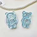 Detailed view of two blue glitter bear phone socket stands on textured leather background - Bear - High-Shine Sequins - Blue