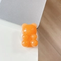 Macro di un supporto per telefono a forma di orsetto arancione trasparente - Gelatina Chiara Arancione