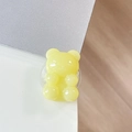 Detailed view of yellow jelly bear phone grip on desk with a transparent base - Light Jelly Yellow