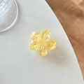 Detailed macro shot of a yellow sequin flower phone grip on a white textured desktop - Cherry Blossom Sugar Heart Style / Yellow