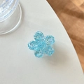 Close-up of a blue glitter flower phone grip with heart sequins on a white surface - Cherry Blossom Sugar Heart Style / Blue
