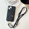Dettaglio custodia iPhone in pelle nera a grana con porta carte a fiocco e tracolla - Nero / iPhone 17 Promax