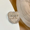 Macro shot of heart-shaped phone grip with tweed fabric and rhinestone bow detail - Magnetic Rhinestone Heart Bow-Woven Texture / Khaki