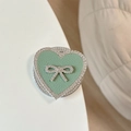 Macro detail of heart-shaped phone grip with green leather and rhinestone bow design - Magnetic Rhinestone Heart Bow-Leather Texture / Green