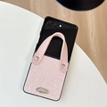 Close-up of pink leather phone case for Samsung Z Flip with wrist strap and metal logo - For Samsung Z Flip 3 / Pink