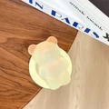 Dettaglio macro del supporto Magsafe a forma di orso olografico 3D su legno - Giallo fantasma