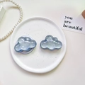 Close-up of glitter cloud phone socket stands on a decorative white porcelain plate - Pearlescent Cloud-Silver Gray