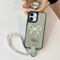 Detail of light green leather iPhone case with bowknot and luxury pearl wrist strap - Green / iPhone 16e