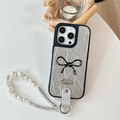 Close-up of silver wrinkled leather iPhone case with polka dot bow and pearl wrist strap - Silver / iPhone 16e