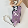 Detail of purple leather phone case with white polka dot bow and pearl wrist strap - Purple / iPhone 16e