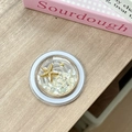 Detail view of round ocean theme phone grip with starfish and shell inlay on wood surface - Magnetic Starry Sky Starfish Shell Stone / Off-white